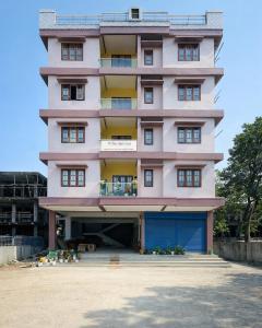 a pink building with a lot of windows at White Lotus in North Lakhimpur