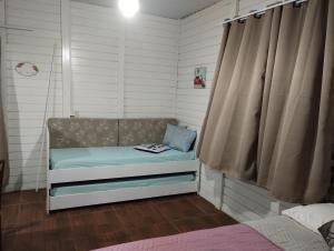 a small room with a bench in a bedroom at Cabano rosa sul in Garopaba