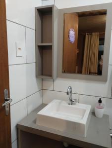 a bathroom with a sink and a mirror at Cabano rosa sul in Garopaba