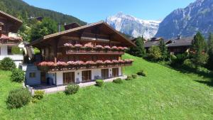 a house with flowers on the side of a hill at Apartment Bärgrose - GRIWA RENT AG in Grindelwald