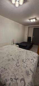 a bedroom with a bed and a couch at Studio 33 m2 a saint Michel de Maurienne in Saint-Michel-de-Maurienne