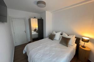 a bedroom with a white bed and a mirror at Bay View Village - Villa Eléanore 1 in MitroviÄ‡i