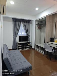 a living room with a couch and a television at Chalet Kurung Tengar in Kuala Perlis