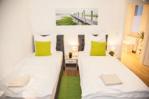 two beds in a room with green and white pillows at Apartment Haus Heidelberg in Heidelberg