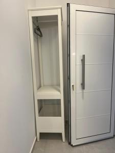 a white closet with a glass door and a shelf at The Minimal Apartments 3Floors in Loutra Edipsou +72 photos