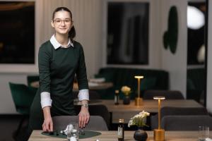 Eine Frau steht vor einem Tisch in der Unterkunft Hotel Görtler in Seesen