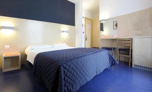 a bedroom with a bed with a blue comforter at Hotel Firenze in Bibione +162 photos