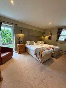a large bedroom with a large bed and a chair at New Farm Cheshire B&B in Winsford