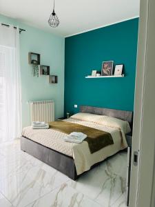a bedroom with a large bed with a blue wall at A casa di Ro 2 in Nola