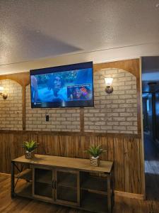 a living room with a flat screen tv on a brick wall at Mem's Place in Bluefield