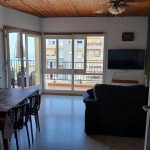 a living room with a couch and a table and a television at Mar y Sol in Calafell