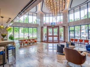 a large lobby with tables and chairs and windows at Yilan Yunjing Boutique Hotel in Beijing