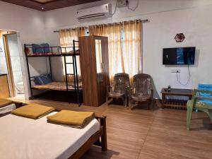 a room with two bunk beds and a table and chairs at Gokarna City Guest House in Gokarna