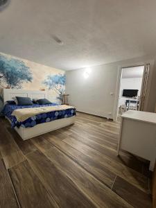 a bedroom with a bed and a painting on the wall at B&B Blue Dragonfly in Paesana