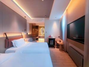 a hotel room with a bed and a flat screen tv at Yilan Yunjing Boutique Hotel in Beijing