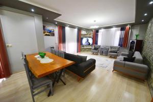 a dining room with a table and chairs and a living room at Gold villa in Fethiye