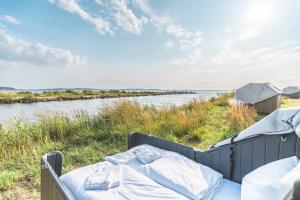 a bed in the grass next to a body of water at Marina Martinshafen - Beach life in Sassnitz