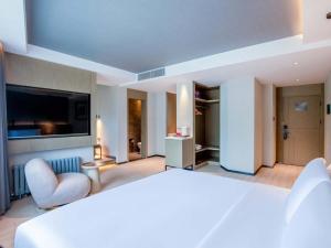 a hotel room with a bed and a television at Yilan Yunjing Boutique Hotel in Beijing