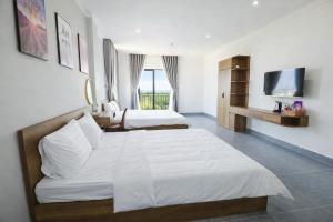 a hotel room with two beds and a television at Hoa Dã Quỳ Hotel in Pleiku