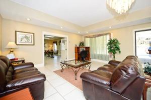 - un salon avec des canapés en cuir et une table dans l'établissement Manchester Heritage Inn & Suites, à Manchester