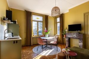 eine Küche und ein Wohnzimmer mit Tisch und Stühlen in der Unterkunft B&B d'Ouwe Grutter in Wagenberg