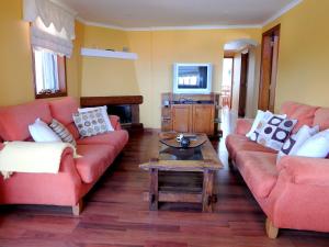 a living room with two red couches and a coffee table at Finca La Chamusca in Icod de los Vinos