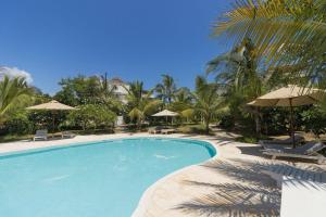a swimming pool with chairs and umbrellas at Villa Rebecca 1 at Paparemo Village in Watamu