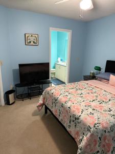 a bedroom with a bed and a flat screen tv at Serenity in Statesboro