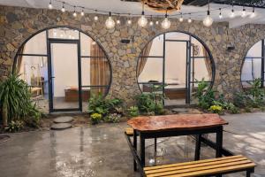 a room with a table and a stone wall at Tròn Homestay Vĩnh Hy in Vĩnh Hy