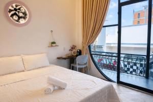 a bedroom with a bed and a balcony at Tròn Homestay Vĩnh Hy in Vĩnh Hy