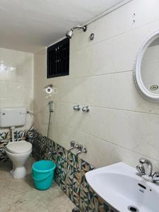 a bathroom with a toilet and a sink and a mirror at Nibha Homestay Near Guwahati Railway station 2BHK in Guwahati