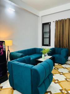 a living room with a blue couch and a table at Nibha Homestay Near Guwahati Railway station 2BHK in Guwahati