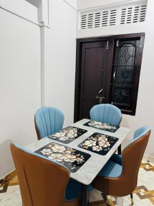 a dining room table with blue chairs and a table cloth at Nibha Homestay Near Guwahati Railway station 2BHK in Guwahati