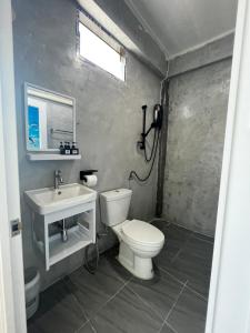 a bathroom with a white toilet and a sink at The cozy house in Trang