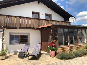 two chairs on a patio in front of a house at Ferienhaus Kollmer in Bad Koetzting