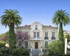 a house with two palm trees in front of it at Résidence La Villa Léonie in Nice