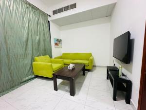 a living room with a yellow couch and a table at Villa 16 in Abu Dhabi