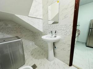 a white bathroom with a sink and a toilet at Villa 16 in Abu Dhabi