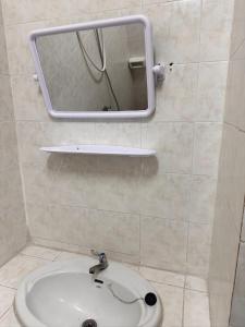 a bathroom with a sink and a mirror on the wall at Nana's Apartment in Pattaya