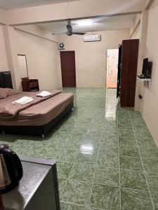 a room with two beds and a green tiled floor at Nana's Apartment in Pattaya