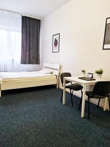 a room with a bed and a table and chairs at mHostel24 in Lublin