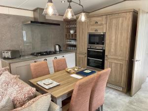 a kitchen with a wooden table with chairs and a dining room at The Royal Oak - Sleeps 4 - Deck - Free Parking in Holsworthy +2 photos