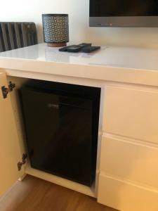 a microwave oven in a cabinet with a counter top at La chambre au piano in Tilly-sur-Seulles