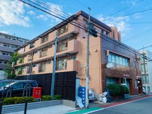 a pink building on a city street at HOTEL k&m in Tokyo