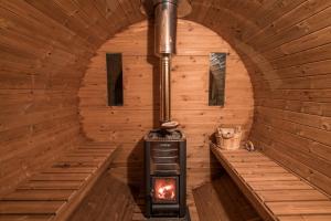 an inside of a sauna with a stove in it at Penzión Pod Guglom in Mlynky  +61 photos