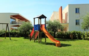 un parque infantil con un tobogán en el césped en Sporting Club Resort, en Praia a Mare