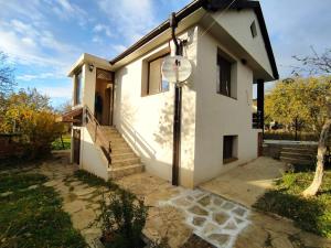 a house with a clock on the side of it at къща за гости При Приятели in Nesebar