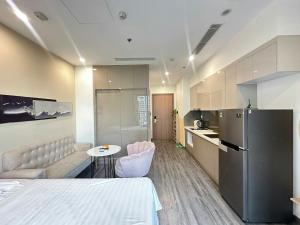 a kitchen with a couch and a table and a refrigerator at R1 Studio Ruby Zenpark in Gia Lâm Pho +7 photos