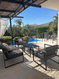 a patio with a table and chairs and a pool at Villa LeANN in Okrug Donji