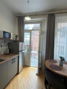 a kitchen with a table and a refrigerator and a window at Old Gold Anteon in Tbilisi City +54 photos